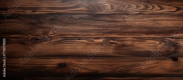 Fototapeta A close up of a brown hardwood table with a wood stain finish, showcasing the beautiful grain pattern of the wood. The blurred background features a cloudy landscape