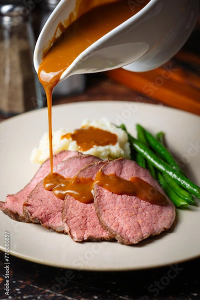 Obraz  pouring brown gravy sauce on roasted beef