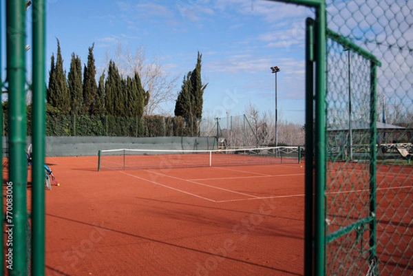 Obraz Panoramic view from the front door of an empty clay tennis court during a sunny day