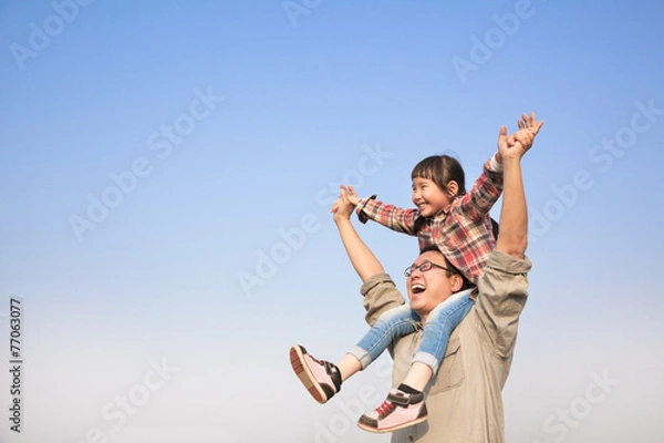 Obraz Father carrying his daughter on shoulders with blue sky backgrou