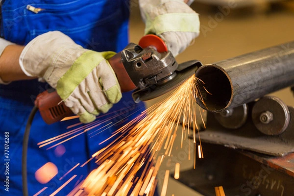 Obraz Worker cutting steel with angle grinder