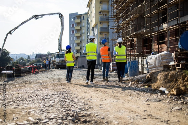 Fototapeta Four construction workers having meeting.