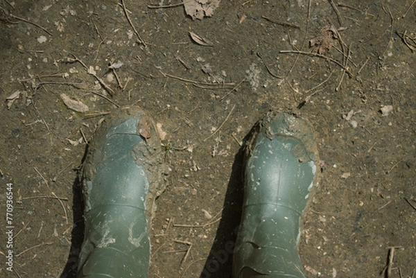 Obraz Rubber boots dirty with mud. Concept of adventure and tourism.