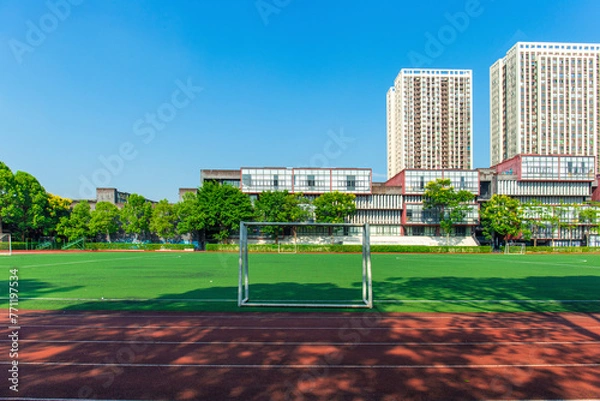 Fototapeta The unmanned outdoor football stadium is located on the university campus, with clear skies