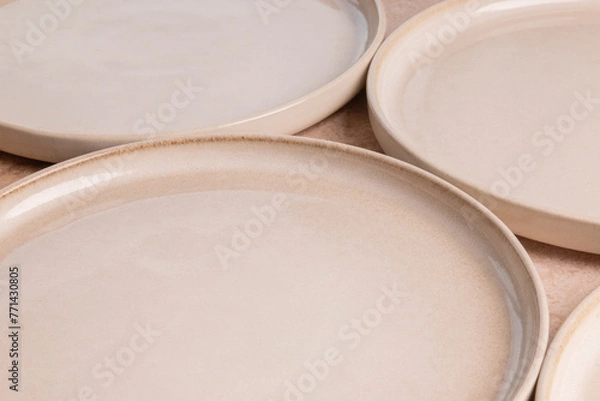 Obraz Beige ceramic dinner plates on a brown stone tabletop.