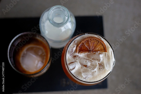 Fototapeta selective focus, cool, fizzy drinks with ice Craft cola with white foam Decorate with a lemon slice on top. A refreshing drink made from herbs. At the Chiang Mai cafe