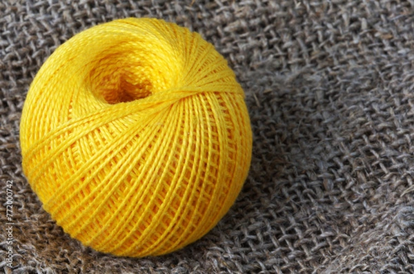 Fototapeta A skein of yellow thread on canvas. Yarn, ball, thread, fluffy, ball, handmade, craft, object, woolen, skein, material, homemade, hobby, traditional, creative