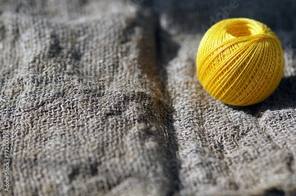Fototapeta A skein of yellow thread on canvas. Yarn, ball, thread, fluffy, ball, handmade, craft, object, woolen, skein, material, homemade, hobby, traditional, creative