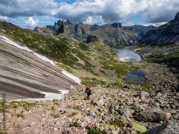 Obraz Heavy uphill climb with a big backpack.