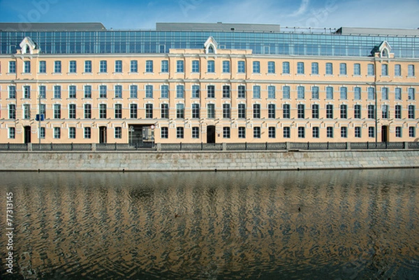 Obraz Long yellow business bulding on a river