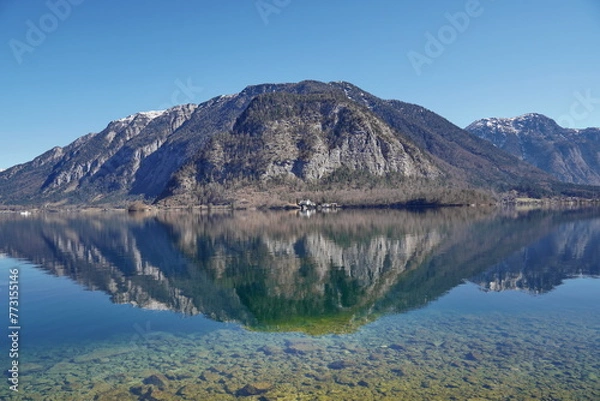 Fototapeta Picturesque view of the lake with the reflection of the rocky mountain, Hallstatt, Austria.