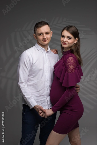 Obraz two people, portrait of a pregnant couple on a grey background, pregnant couple close up, future parents, studio pregnancy photo shoot
