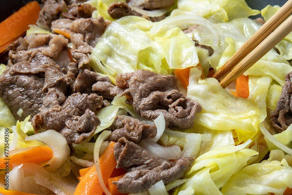 Obraz 牛肉と野菜をフライパンで炒める調理シーン。
