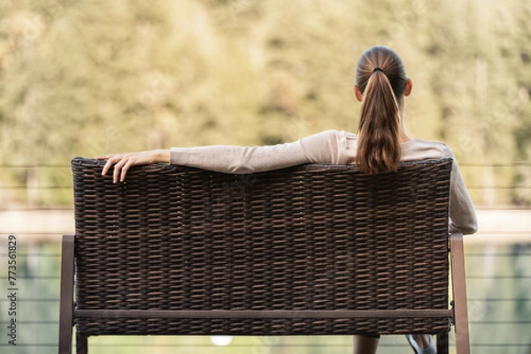 Fototapeta woman sitting on a park bench alone 