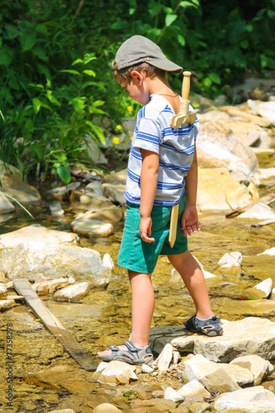 Obraz The kid plays near a mountain stream