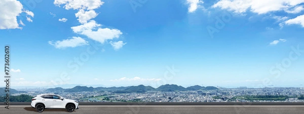 Obraz 青空と街並みを背景に車でドライブ