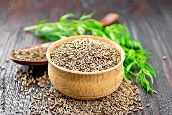 Obraz Cumin seeds in bowl and spoon with herbs on board