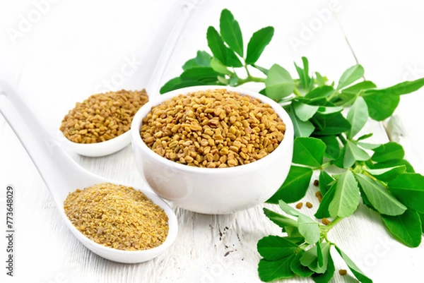 Obraz Fenugreek in bowl and two spoons with leaves on white board