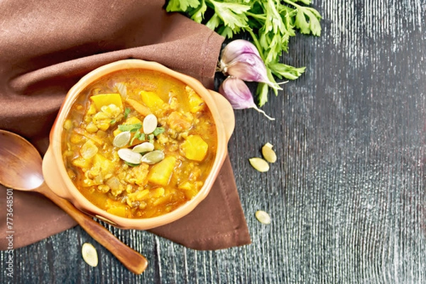 Obraz Soup-curry with pumpkin and lentils in bowl on dark board top