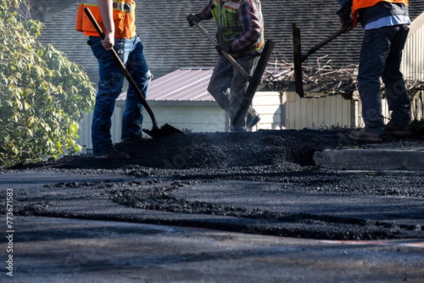 Obraz Steamroller compacting freshly load asphalt with pile of hot asphalt at end, residential road repaving construction project
