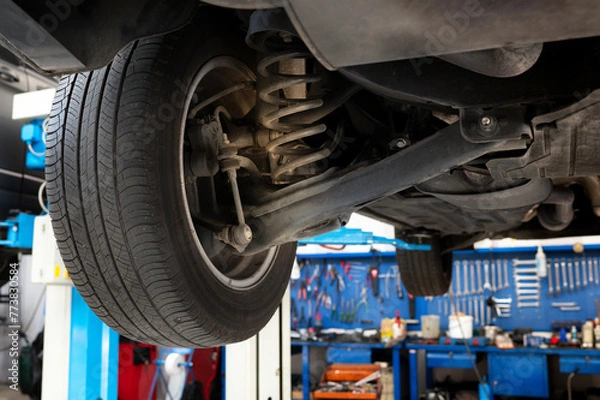 Fototapeta Underneath view of car with shock absorber
