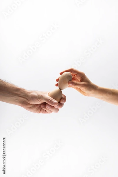 Fototapeta Hands tapping eggs. Easter. Unbreakable concept.