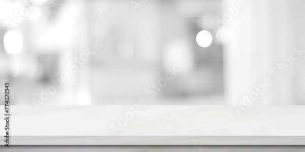 Obraz Vertical empty white table top, counter, desk over blur perspective store with bokeh light background, White marble stone table, shelf and blurred shop for food, product display mockup