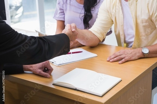 Fototapeta Close up of salesman shaking a customer hand