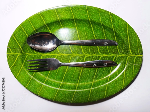 Obraz Empty green plate leaf pattern theme with spoon and fork isolated white background