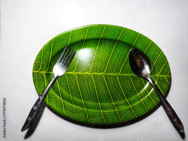 Obraz Empty green plate leaf pattern theme with spoon and fork isolated white background