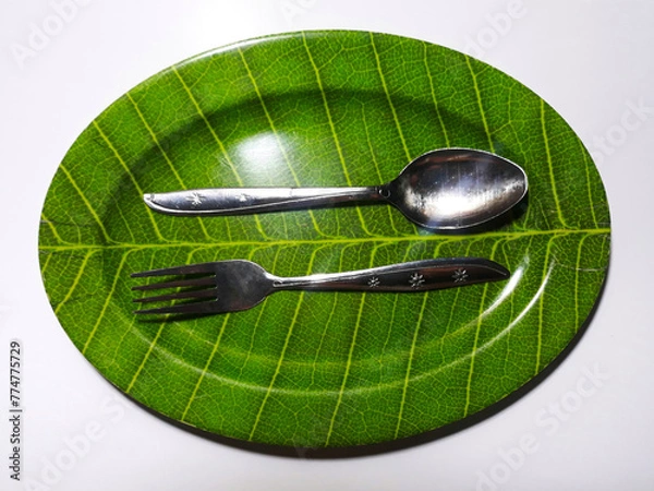 Obraz Empty green plate leaf pattern theme with spoon and fork isolated white background
