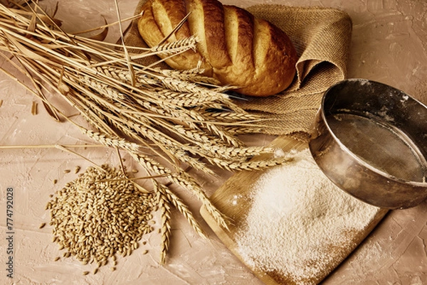 Obraz a loaf of bread,a sieve, coarse flour, grains and ears of wheat