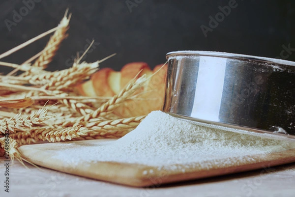 Obraz a loaf of bread,a sieve, coarse flour, grains and ears of wheat