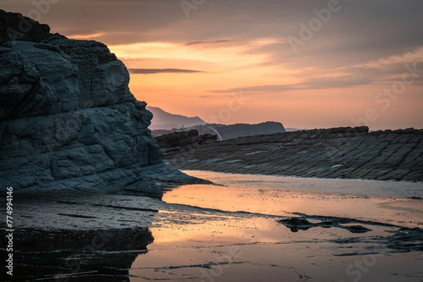 Obraz Sunset time at the coastline of Badouzi, sunlight shines on the water with gorgeous rocks by the side, in Keelung city, Taiwan.