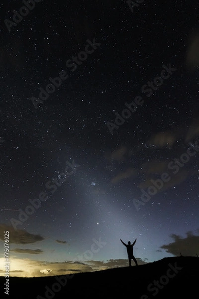 Obraz A stargazer having his hands open wide in the night sky silhuette showing the zodiacal light in the sky.