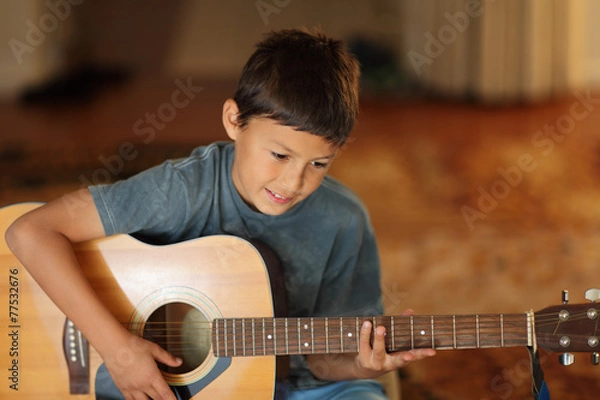Obraz Young boy playing a guitar
