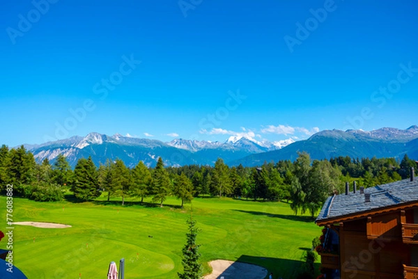 Fototapeta Panoramic View over Mountain with Snow and Weisshorn with 4505 Meters High and Golf Course with Clouds in Crans Montana, Valais in Switzerland.