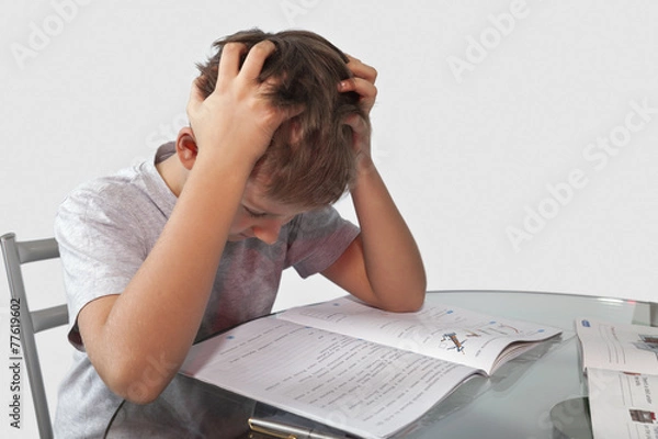 Obraz boy does his homework on a glass table