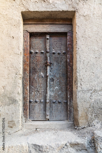 Fototapeta An old wooden door on an adobe building in Bukhara.
