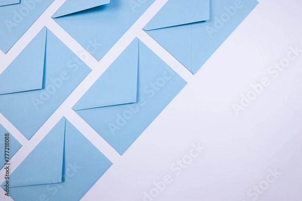 Fototapeta Top view of light blue envelopes on white background. Post flat lay. Copy space.