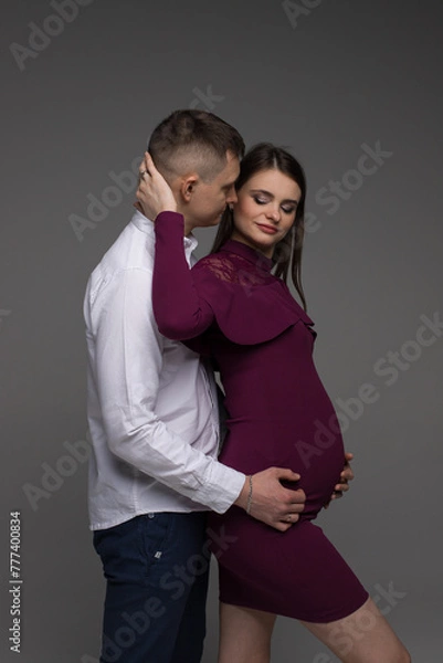 Obraz portrait of a couple, pregnant couple, pregnant woman on a grey background, 9 month