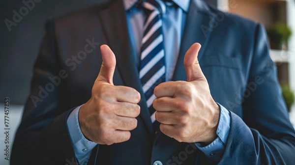Fototapeta Business man thumbs up to indicate success, likes,encourages, wins - close-up.
