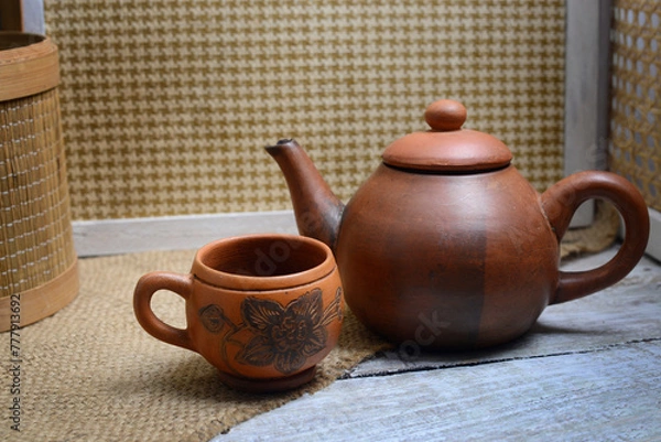 Fototapeta Teapots, teapots, places to brew and drink tea from terracotta, made traditionally, wooden background and natural wicker