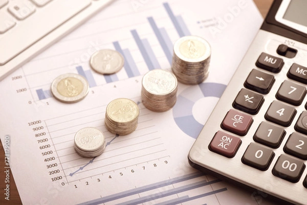 Obraz Financial concepts - coins and calculators placed on financial data reports