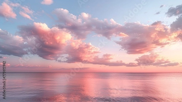 Fototapeta Cirrus clouds tinted pink by the sun at sunset over a calm blue ocean