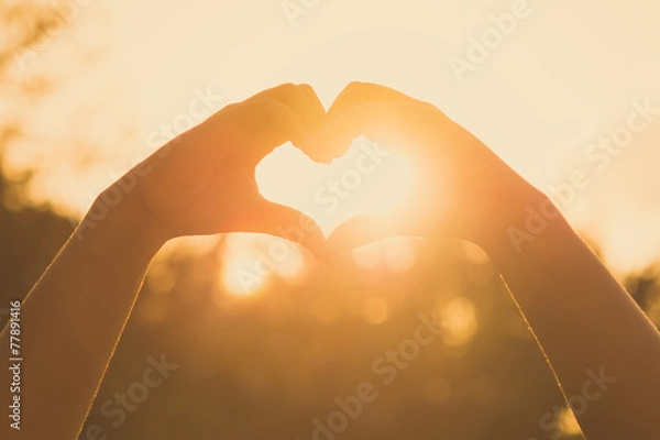 Fototapeta hands forming a heart shape at sunset
