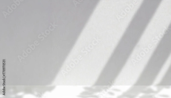 Fototapeta Soft and geometric shadows on a white wall. Part of the wall is light, part is in shadow