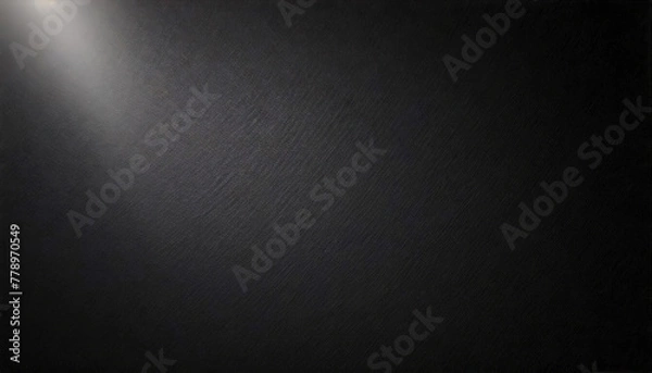 Fototapeta Open space on a black wall with a narrow beam of light from top left