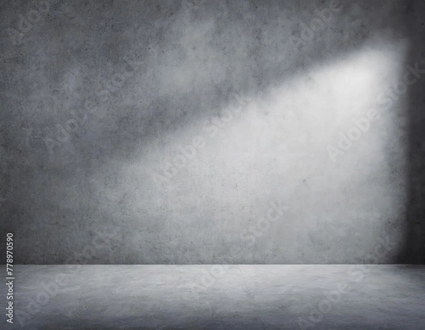 Fototapeta Open space of a large room with gray walls and gray floor, light from the window on the right on the wall