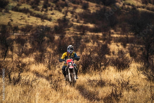 Fototapeta Professional enduro bike rider on action, front view of the motorcycle rider driving on the mountains